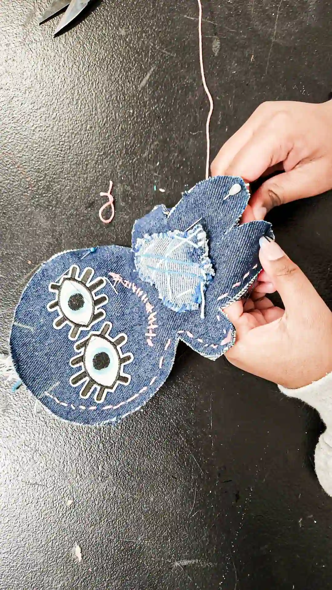 Élève couds un poupée doo en denim recyclé lors d’un atelier de couture scolaire Textilab