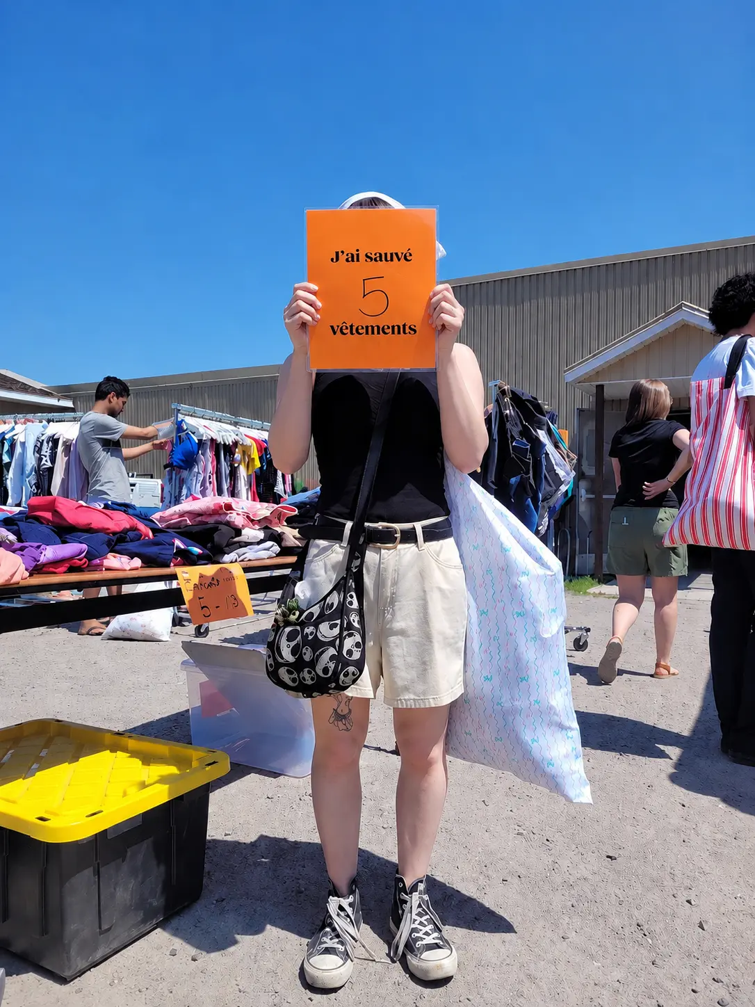 Jeune participante au Stop à Max tenant une affiche indiquant qu’elle a sauvé cinq vêtements.
